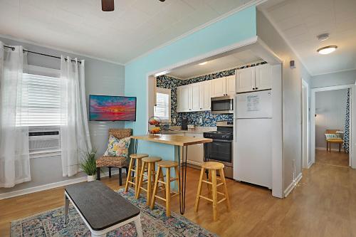 a kitchen with a white refrigerator and a table and chairs at Steps to Beach & Downtown! Cozy Beach Bungalow #1 in Lake Worth