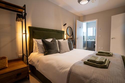 um quarto com uma cama grande e toalhas em Lambert House Two em Harrogate