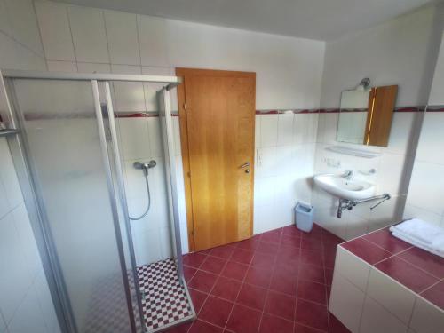 La salle de bains est pourvue d'une douche et d'un lavabo. dans l'établissement Oberstockachhof, à Schwendau