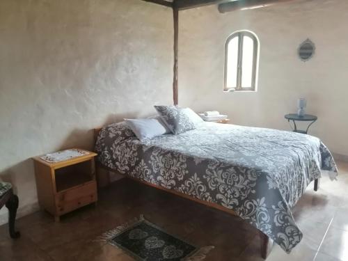 a bedroom with a bed with a blue and white comforter at Refugio Samay Toa in Hacienda Gualovi