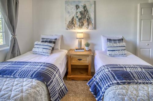 two twin beds in a bedroom with a lamp on a table at 28 Dragoon Ct in Pagosa Springs