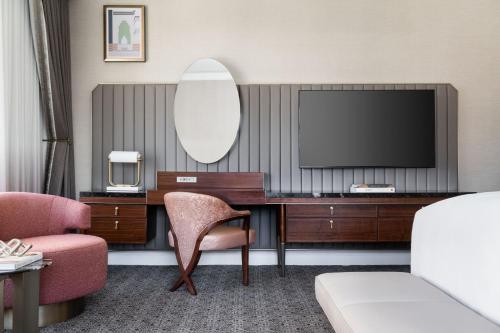 a hotel room with a desk and a television at The Ritz-Carlton, Dallas in Dallas