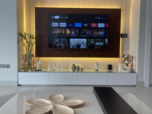 a room with a large display of movies on a wall at A luxury three-bedroom apartment in the heart of Riyadh in Riyadh