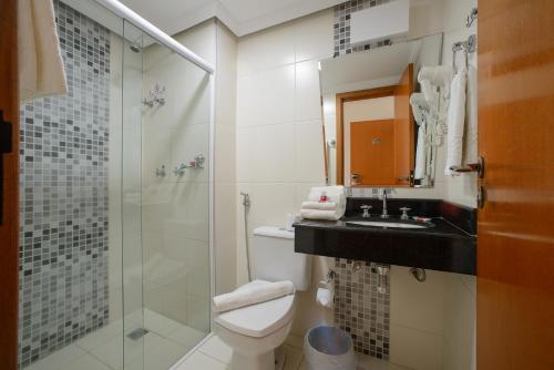 a bathroom with a toilet and a sink and a shower at Faro Hotel São José dos Campos in São José dos Campos