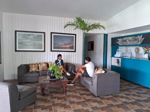two men sitting on couches in a living room at Hostel SaltWater in San Juan del Sur