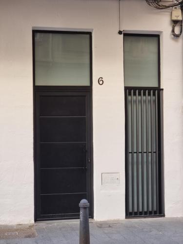 a black door and two windows on a white building at cactus loft Ruzafa in Valencia
