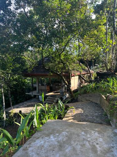 a path leading to a gazebo in a garden at Jansen’s Bungalow Sinharaja Rainforest Retreat in Kudawe