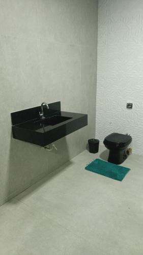a bathroom with a black sink and a toilet at Casa de férias in Montes Claros