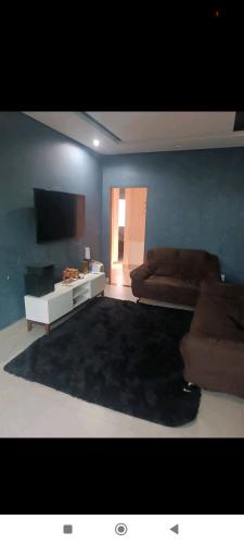 ein Wohnzimmer mit einem Sofa und einem Flachbild-TV in der Unterkunft Casa de férias in Montes Claros