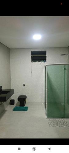 uma casa de banho com uma cabina de duche em vidro e um WC. em Casa de férias em Montes Claros