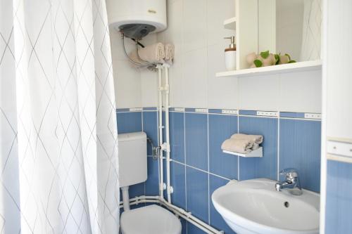 a blue and white bathroom with a toilet and a sink at Little Nook in Čačak
