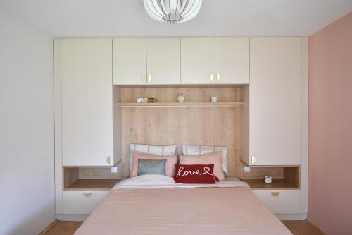 a bedroom with a large bed with white cabinets at Little Nook in Čačak