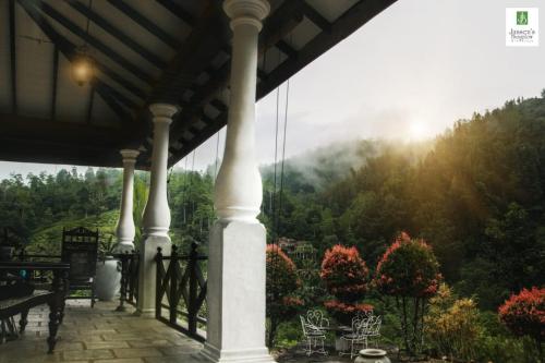 a porch with a view of the mountains at Jansen’s Bungalow Sinharaja Rainforest Retreat in Kudawe