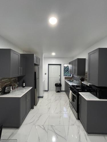 a large kitchen with black appliances and white tile floors at Enchanted Escapades in Vieux Fort