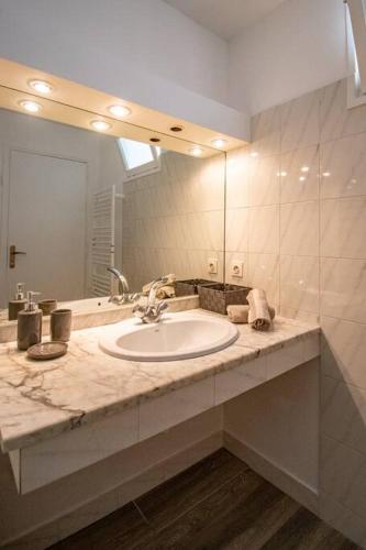 une salle de bain avec un lavabo et un grand miroir dans l'établissement Les quatre loges n°1, à Aix-en-Provence