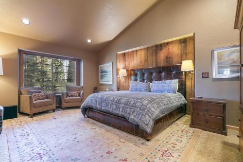 una camera da letto con un letto grande e una sedia di Alpen Glow by Tahoe Getaways - Private Hot Tub, Close to Northstar a Carnelian Bay
