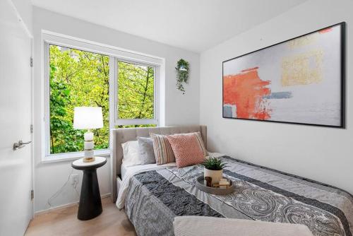 a living room with a bed and a window at Elegant 2-Bedroom Duplex Haven in Vibrant Yaletown in Vancouver