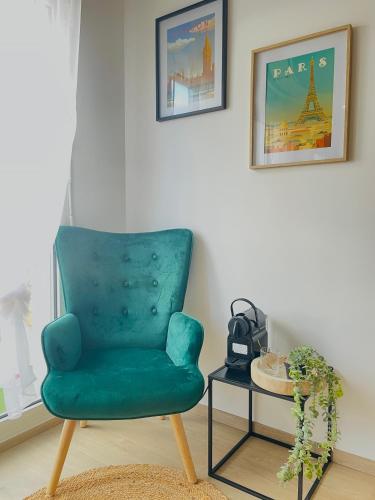 une chaise verte assise dans une pièce avec une table dans l'établissement Nancy Gare - Studio Haut de gamme, à Nancy