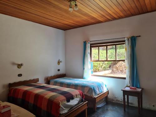 1 dormitorio con 2 camas y ventana en Casa Campo Tipo Fazenda en Mairinque