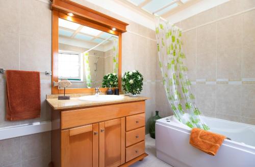 een badkamer met een wastafel, een bad en een spiegel bij Aroeira Villa - Sea & Golf in Aroeira