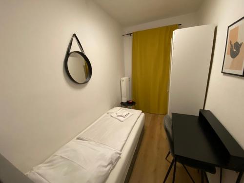 Habitación hospitalaria con cama y espejo en Swan Rooms en Núremberg