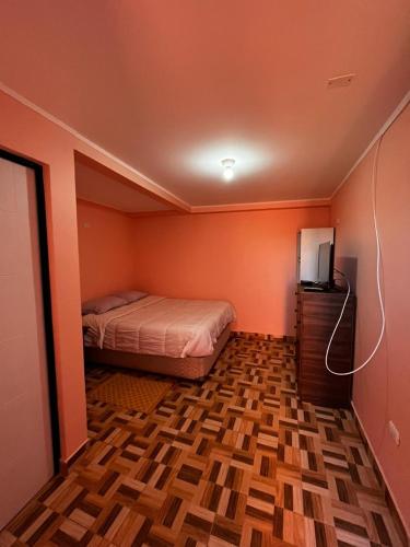 een slaapkamer met een bed en een televisie. bij Hostal nuevo sol y viento 2 in San Pedro de Atacama