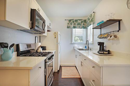 a kitchen with white cabinets and a stove top oven at Steps to Beach & Downtown! Spacious Beach Bungalow #2 in Lake Worth