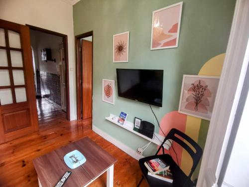 uma sala de estar com uma televisão de ecrã plano na parede em Tradicional Portuguese Apartment em Lisboa