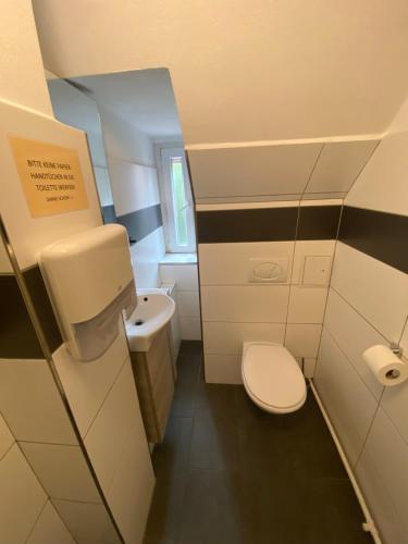 a small bathroom with a toilet and a sink at Swan Rooms in Nürnberg