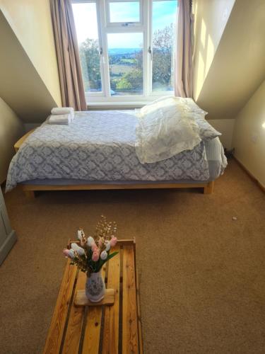 a bedroom with a bed and a vase of flowers on a table at Ensuite spare room in family home Dudley in Sedgley