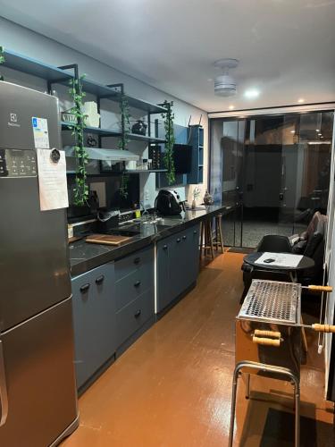 a kitchen with stainless steel appliances and a table at Casa Container Blackhawk in Pirassununga