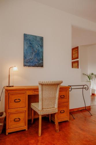a desk with a chair and a painting on the wall at La Poza Boutique Hotel and Spa - Adults 15 plus in Todos Santos