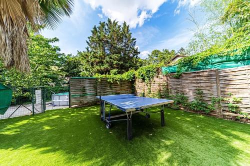 una mesa de ping pong en un patio con una valla en Maison Frappaz 4 chambres avec jardin Villeurbanne en Villeurbanne