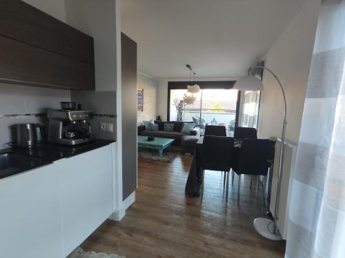 a kitchen and a living room with a table and chairs at Bella Vista - New flat with View Confort & Calm near Geneva 5 PERS in Archamps