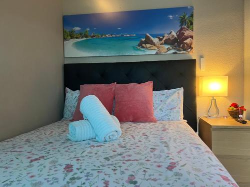 1 dormitorio con 1 cama con almohadas rosas y azules en Habitación Amaya 1, en Las Corts