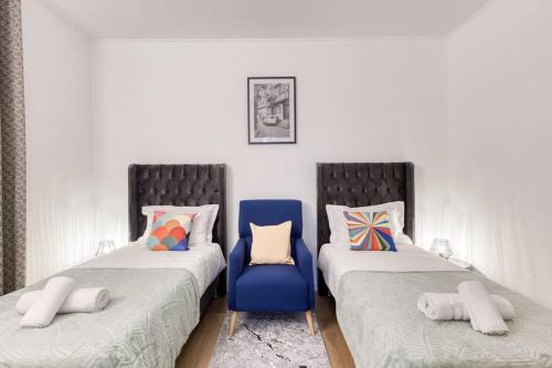 um quarto com duas camas e uma cadeira azul em 40 minutes en voiture de Disneyland Paris em Noisy-le-Sec
