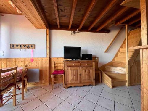 a living room with a tv and a staircase at Chalet Duplex vue sur le lac et pied des pistes in Les Angles