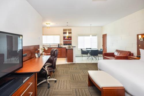 an office with a desk and a living room at Les Suites de Laviolette, an Ascend Collection Hotel in Trois-Rivières