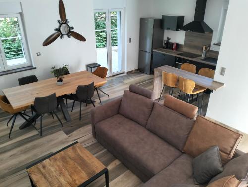 uma sala de estar com um sofá e uma mesa em Au fil de l'eau em Lapoutroie