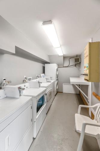 a kitchen with white counters and white appliances at Mountainside at Stowe by CoolVacay in Stowe