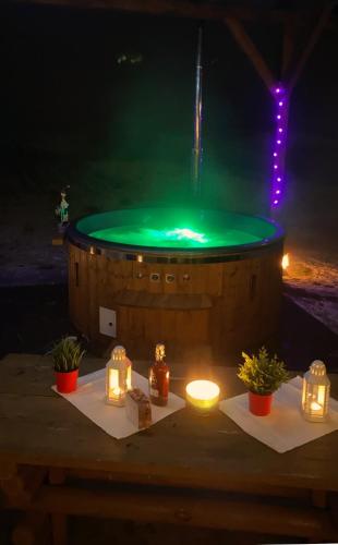 a hot tub with a green fountain with candles and lights at Agrosielanka in Lipnica