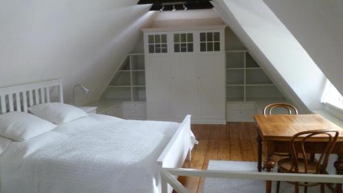 een witte slaapkamer met een bed en een tafel bij Ferienhaus Siedschelje in Schwanewede