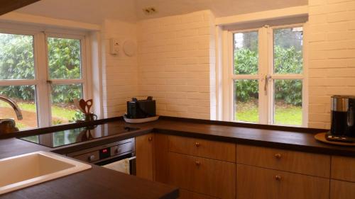 uma cozinha com balcões e janelas de madeira e um lavatório em Ferienhaus Siedschelje em Schwanewede