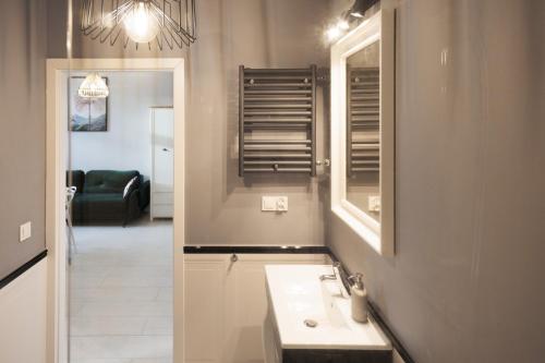 a bathroom with a sink and a mirror at Apartament Piotrkowska 67 Primo in Łódź