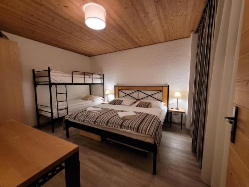 a bedroom with two bunk beds and a table at CHALET ASKALA JASNÁ in Demanovska Dolina