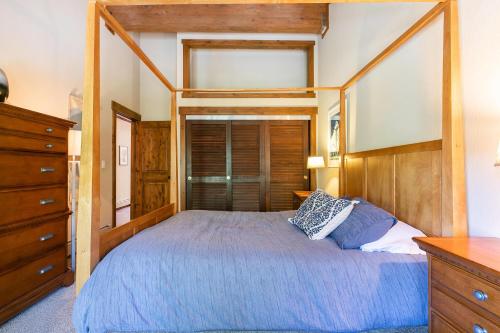 a bedroom with a large bed with a wooden frame at Alpine Escape by Tahoe Getaways - Shuttle to Ski Slopes & Fireplace in Alpine Meadows