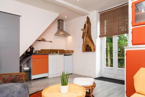 cocina y sala de estar con naranja y blanco en Maisonnette duplex avec jacuzzi/sauna attenant en Saint-Martin-des-Entrées