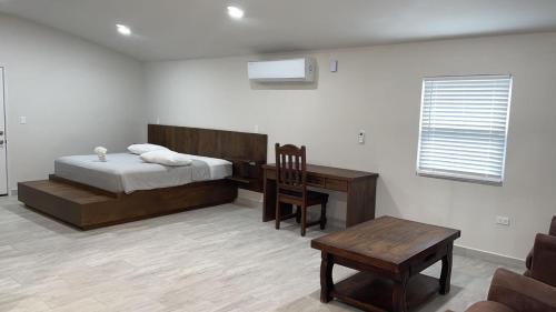 um quarto com uma cama, uma secretária e uma cadeira em Roaring River Golf & Accommodations em Belmopan