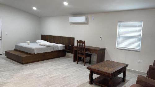 a bedroom with a bed and a desk and a chair at Roaring River Golf & Accommodations in Belmopan