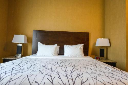 a bedroom with a large bed with two lamps at Best Western Plus South Edmonton Inn & Suites in Edmonton